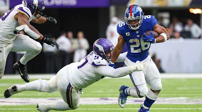 Dec 24, 2022; Minneapolis, Minnesota, USA; New York Giants running back Saquon Barkley (26) is tackled by Minnesota Vikings defensive tackle Harrison Phillips (97) during the fourth quarter at U.S. Bank Stadium.